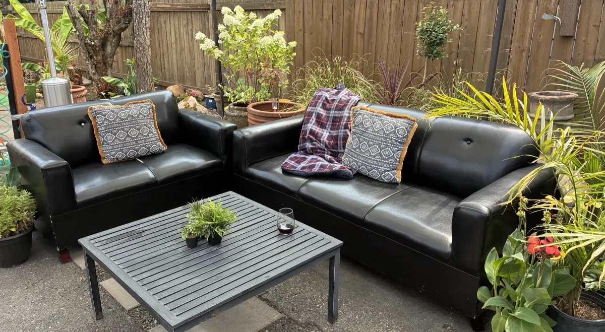 The Back Patio secret garden patio with outdoor lounge sofas and greenery